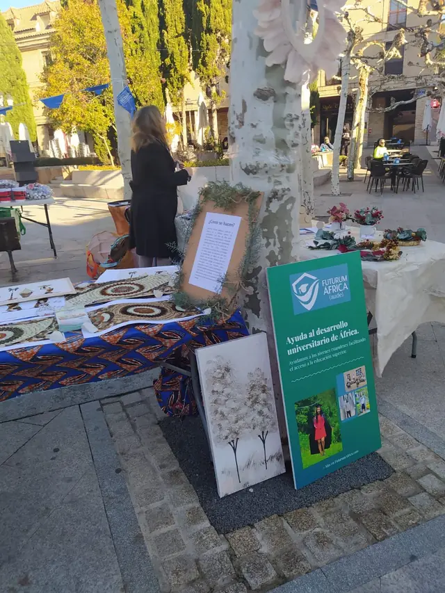 Puesto de AUDE con láminas y el cartel de la asociación