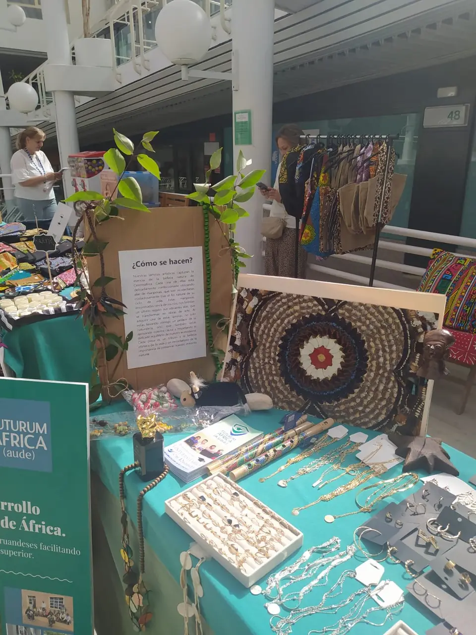 Lámina hecha con alas de mariposa, cartel «¿Cómo se hacen?» y bisutería sobre la mesa